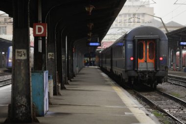 Bükreş, Romanya - 20 Aralık 2021: Karlı bir kış gününde Bükreş 'teki Gara de Nord (Kuzey Demiryolu İstasyonu) tren ve yolcuları.
