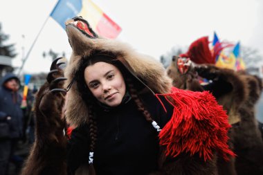 Bükreş, Romanya - 21 Aralık 2021: Genç kadın ayı kürkü giyiyor ve geleneksel bir Yeni Yıl Romanya ayini (Bears Dance or Dansul Ursilor).
