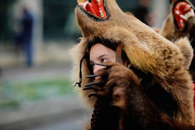 Bükreş, Romanya - 21 Aralık 2021: Genç kadın ayı kürkü giyiyor ve geleneksel bir Yeni Yıl Romanya ayini (Bears Dance or Dansul Ursilor).