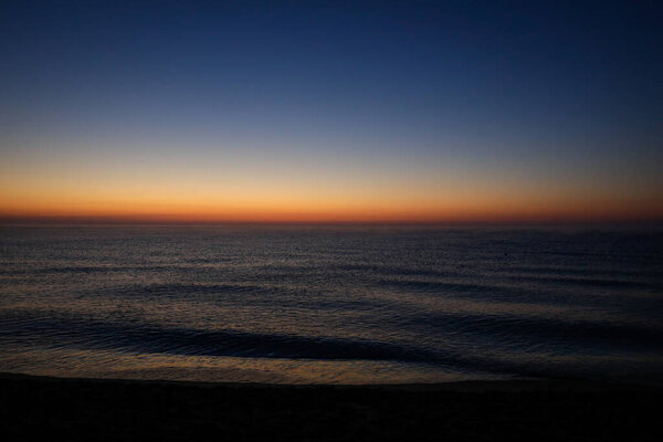 Gentle waves just before the sunrise over the Black Sea in the Obzor resort in Bulgaria on a calm and warm summer day.