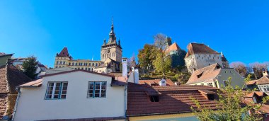 Sighisoara, Romanya - 30 Ekim 2021: Güneşli bir sonbahar sabahında Transilvanya 'nın Sighisoara kasabasındaki ortaçağ saat kulesi.