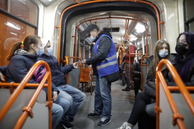 Bükreş, Romanya - 19 Ocak 2022: Bükreş 'teki eski bir tramvayda bilet kontrolü yapan adam.