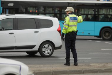 Bükreş, Romanya - 2 Şubat 2022: Romen karayolu polisi kış günlerinde işlek bir caddede trafiği yönetiyor.