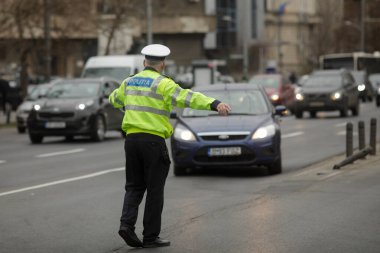Bükreş, Romanya - 2 Şubat 2022: Romen karayolu polisi kış günlerinde işlek bir caddede trafiği yönetiyor.