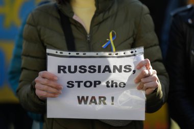 Romanya 'nın Bükreş kentinde düzenlenen savaş karşıtı protesto sırasında elinde savaş karşıtı, Ukrayna yanlısı ve Rusya karşıtı pankart bulunan Ukraynalı bir kadının elleriyle ilgili ayrıntılar.