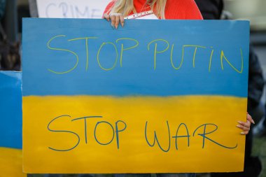 Romanya 'nın Bükreş kentinde düzenlenen savaş karşıtı protesto sırasında elinde savaş karşıtı, Ukrayna yanlısı ve Rusya karşıtı pankart bulunan Ukraynalı bir kadının elleriyle ilgili ayrıntılar.
