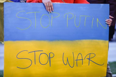 Romanya 'nın Bükreş kentinde düzenlenen savaş karşıtı protesto sırasında elinde savaş karşıtı, Ukrayna yanlısı ve Rusya karşıtı pankart bulunan Ukraynalı bir kadının elleriyle ilgili ayrıntılar.