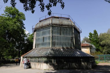 Bükreş, Romanya - 1 Mayıs 2022: Güneşli bir bahar gününde Bükreş 'in Botanik bahçesindeki eski metalik yeşil evler.