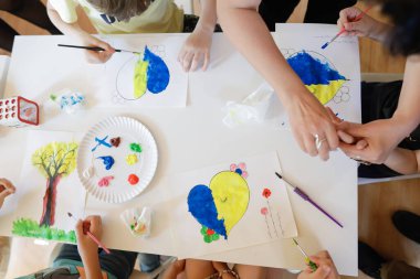 Bükreş, Romanya - 9 Mayıs 2022: Ukraynalı mülteci çocukların bayrakları çizdiği sığ alan derinliği (seçici odak) ayrıntıları.