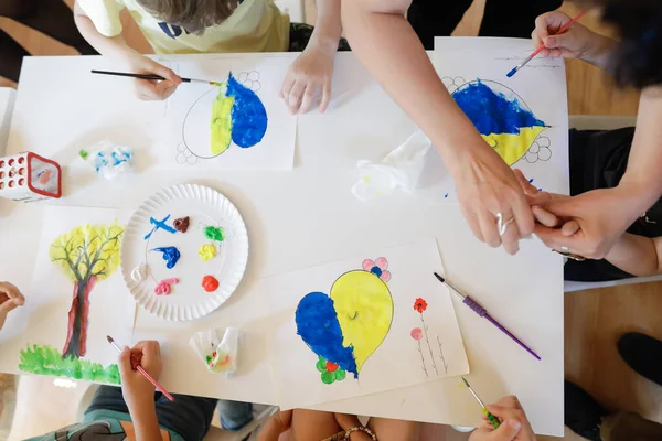 Bükreş, Romanya - 9 Mayıs 2022: Ukraynalı mülteci çocukların bayrakları çizdiği sığ alan derinliği (seçici odak) ayrıntıları.