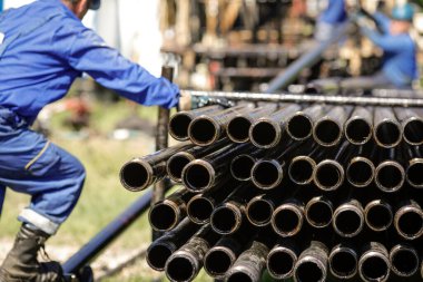 Petrol sondaj boruları arka planda petrol endüstrisi işçileriyle dolu. Petrol ve gaz endüstrisi. Petrol sahasında ham petrol pompası krikosu. Petrol ve gaz kuyularının kazılması.
