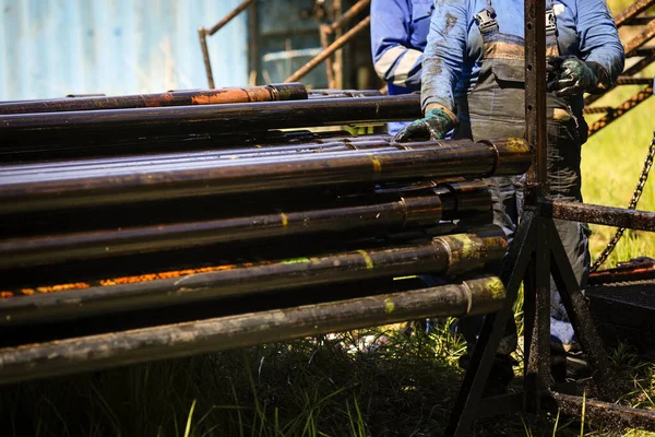 Petrol ve gaz endüstrisi işçisi petrol kuyusu sondaj borularını işletiyor..