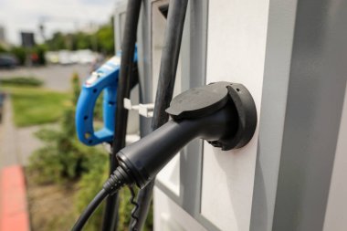 Elektrikli taşıt şarj istasyonunda sığ alan derinliği (seçici odak) ayrıntıları otomatik elektrik prizi veya soketi ile.