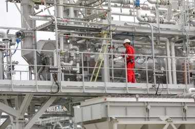 Vadu, Romanya - 28 Haziran 2022: Mühendis bir gaz arıtma tesisinde çalışıyor.