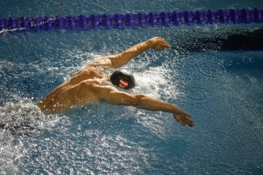 Otopeni, Romania - 8 July 2022: Details with a professional Austrian male athlete swimming in an olympic swimming pool butterfly style.