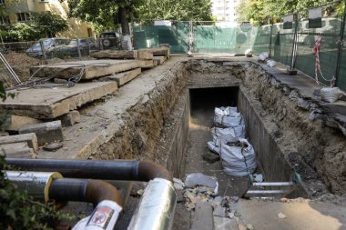 Bucharest, Romania - August 3, 2022: Big hole in the road for workers to repair a RADET (Termoenergetica) pipeline in Bucharest.