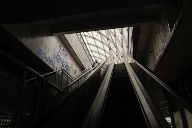 Bucharest, Romania - September 3, 2022: Senior man walks down a dark, dirty and vandalised stairway in Bucharest.