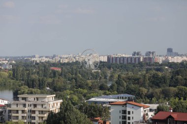 Bucharest, Romania - September 6, 2022: Overview of the northern part of Bucharest, with parks and lake in the foreground and blocks of flats in the background.