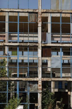 Broken walls and windows in an abandoned industrial building.
