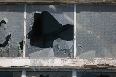 Broken walls and windows in an abandoned industrial building.
