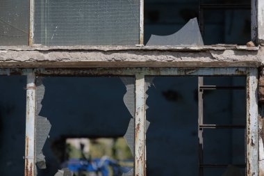 Broken walls and windows in an abandoned industrial building.