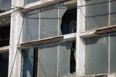 Broken walls and windows in an abandoned industrial building.