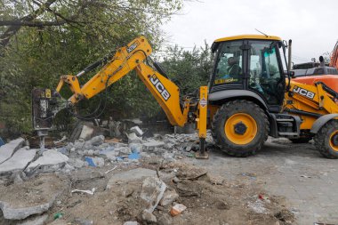 Bükreş, Romanya - 12 Ekim 2022: Küçük bir binayı yıkan kazıcıyla ilgili ayrıntılar.