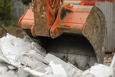 Bir AAC küçük binasını yıkmak için bir kazı kovası (kepçe) ile ayrıntılar.