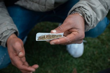 Bogot, Colombia - April 20th, 2022: young man rolling a very big joint