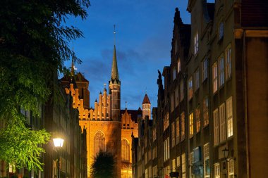 Polonya 'nın Gdansk kentindeki ünlü turistik Mariacka caddesi, alacakaranlıkta St Mary Kilisesi manzaralı.