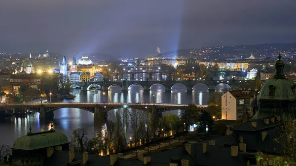 Panoramic view of the cityscape of Prague, Czech Republic, with the various bridges over Vltava River and the gothic architecture of the old town at night — Stock Photo, Image