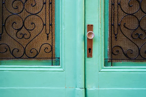 Puerta vintage de estilo mediterráneo antiguo con mango, ojo de cerradura y piezas de vidrio con celosías forjadas — Foto de Stock