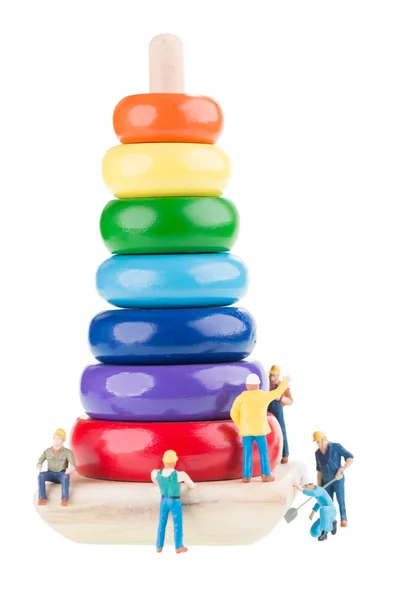 A team of miniature construction workers building a pyramid towe — Stock Photo, Image