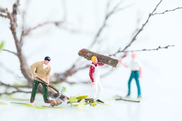 Miniature workmen working together in felling and cutting trees — Stock Photo, Image