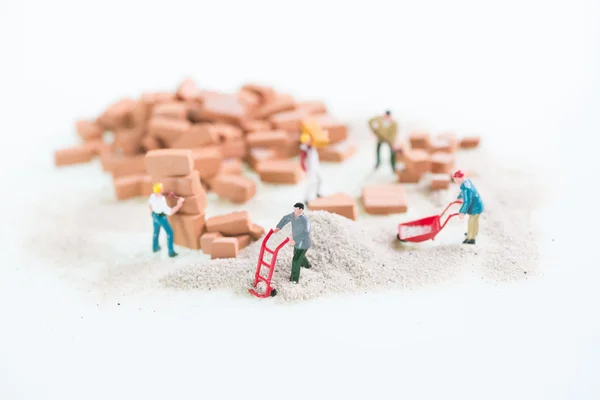 Miniature workmen doing construction brick work top view — Stock Photo, Image