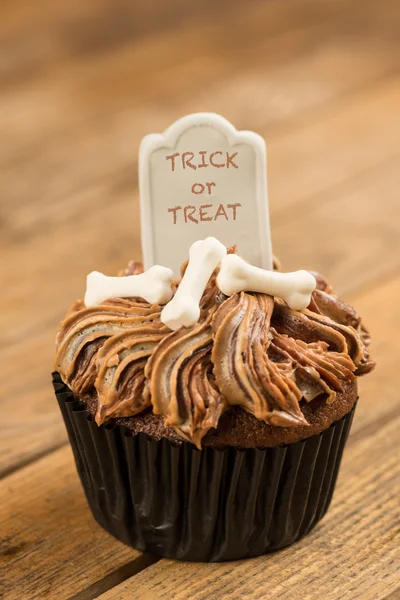 Halloween-Cupcake mit Trick oder Leckerli-Aufschrift auf dem Grabstein-Topper in Großaufnahme — Stockfoto