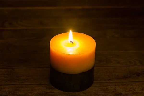 Vela encendida en una mesa de madera — Foto de Stock