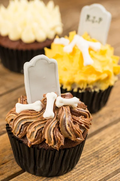 Variace halloween cupcakes na rustikální dřevěný stůl — Stock fotografie