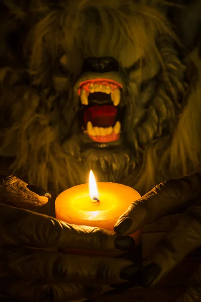 Werewolf head and the hands cradling a candle — Stock Photo, Image