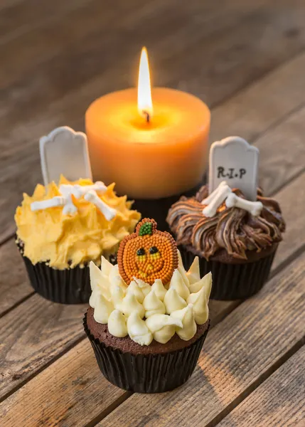 Cupcakes de Halloween e uma vela na velha mesa de madeira rústica vista superior Imagem De Stock