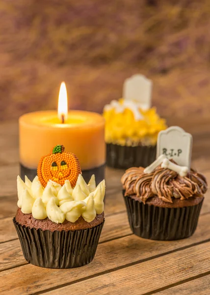 Variación de cupcakes y velas de Halloween en una mesa de madera rústica — Foto de Stock