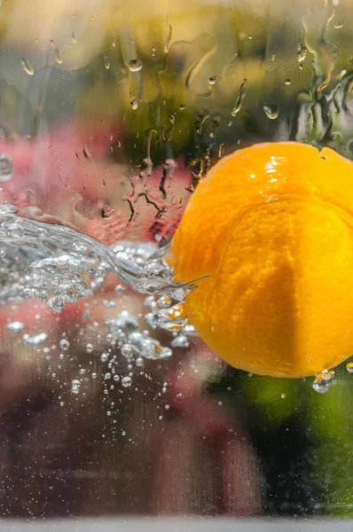 Arancione che cade in acqua con spruzzi naturali — Foto Stock