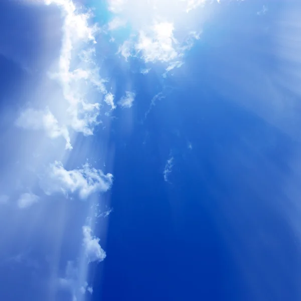 Céu azul com nuvens brancas e raios sutis de luz solar — Fotografia de Stock