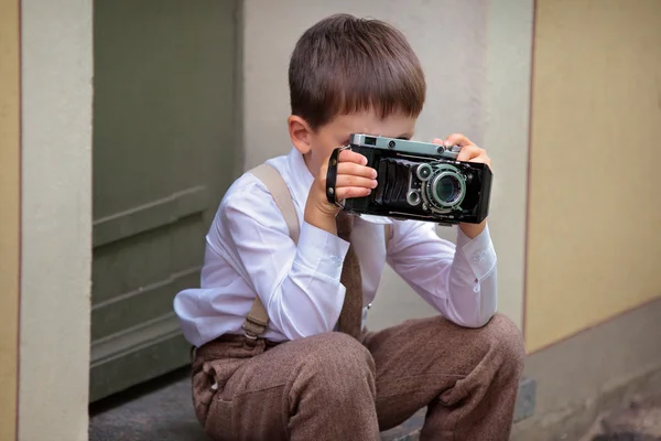 Mignon petit garçon avec caméra rétro en plein air — Photo