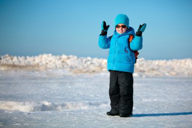Kış sahilde oynarken sevimli küçük çocuk