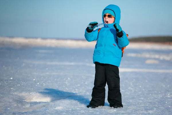 Милый мальчик веселится на зимнем пляже — стоковое фото