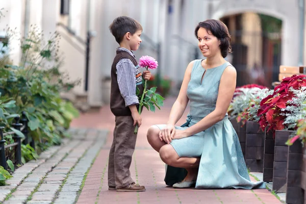 Zoontje een bloem geven moeder — Stockfoto