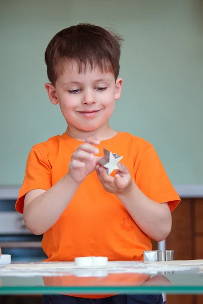Vijf jaar oude jongen helpt zijn moeder cookies maken — Stockfoto