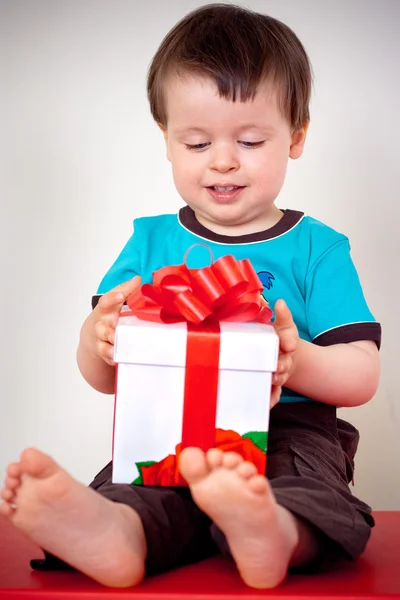 Maluch zadowolony chłopak otwierając pudełko — Zdjęcie stockowe