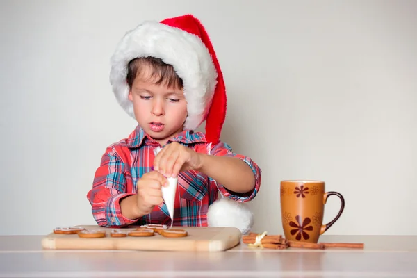 Mignon petit garçon décorant les biscuits au pain d'épice — Photo